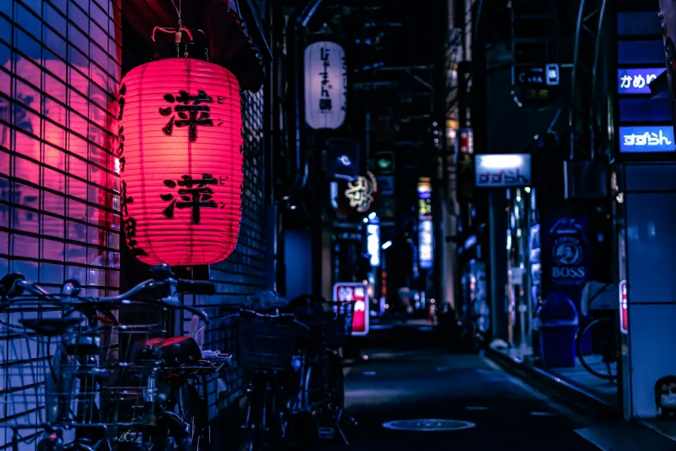 Neon-lit alley with a red paper lantern — the mood of the lounge